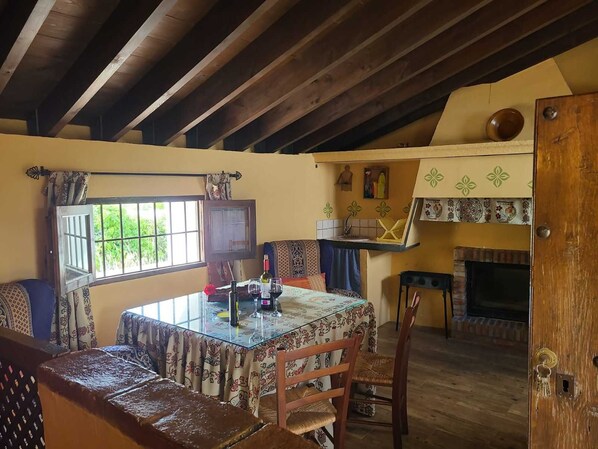 A dining area with a glass table, chairs, and a fireplace.