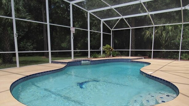 A swimming pool with a tiled edge, surrounded by a covered area with a grid structure. - Ref 24 Modern 4 Bed Villa With own South Facing Pool (Kissimmee)