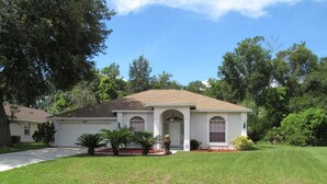 A single-story house with a front porch, a garage, and a well-maintained lawn. - Ref 24 Modern 4 Bed Villa With own South Facing Pool (Kissimmee)