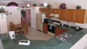 A compact kitchen with wooden cabinets, a built-in oven, a microwave, and a sink. - Ref 24 Modern 4 Bed Villa With own South Facing Pool (Kissimmee)