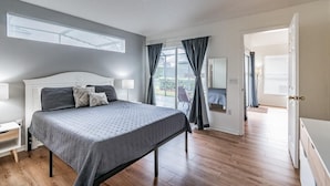 A bedroom with a bed, bedside tables, a window with blinds, and a view of the outdoors. - Ref 16 Stunning 4 Bed Villa on 5 Star Resort Near Disney (Kissimmee)