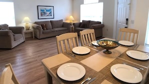 A dining area with a table set for four, surrounded by two sofas and two chairs. - Ref 16 Stunning 4 Bed Villa on 5 Star Resort Near Disney (Kissimmee)