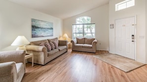 A spacious living room with two sofas, a coffee table, and a painting on the wall. - Ref 16 Stunning 4 Bed Villa on 5 Star Resort Near Disney (Kissimmee)