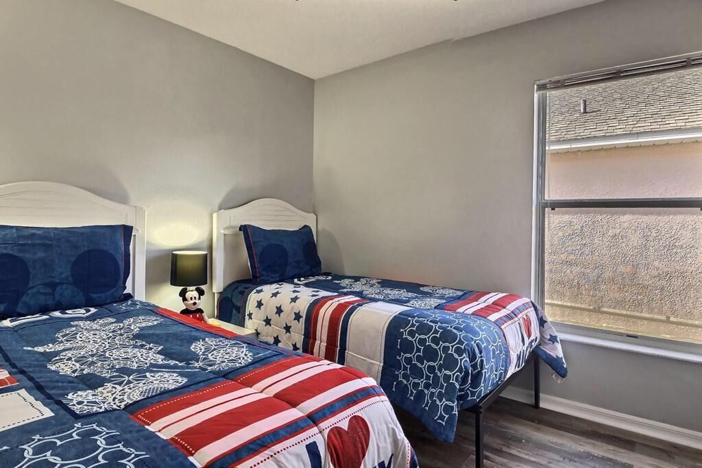 A bedroom with two beds, each with a distinct patterned bedspread.