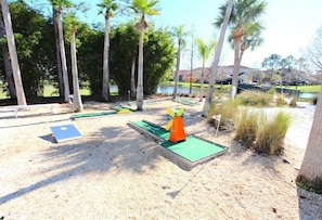Enjoy a round of golf on the putting green, surrounded by palm trees and a tranquil body of water.