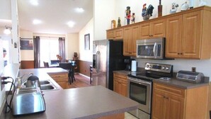 A modern kitchen with wooden cabinets, stainless steel appliances, and a granite countertop. - Ref 43 Family Villa With own Pool Near Disney (Kissimmee)
