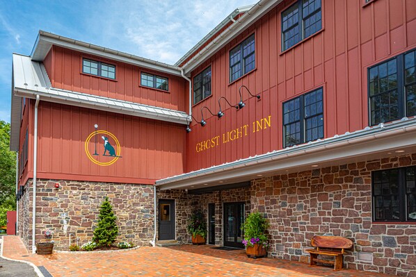 A red building with a stone facade and a sign that reads "GHOST LIGHT INN".