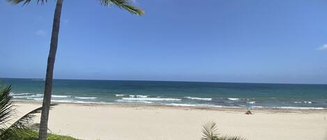 Rannalla, aurinkotuoleja, rantapyyhkeitä