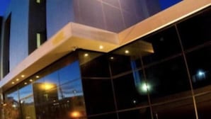 Un edificio moderno con facciata in vetro e ringhiera metallica.