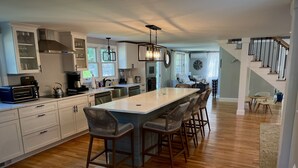A spacious kitchen with a large island, wooden flooring, and modern appliances.