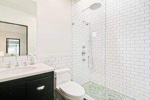 A modern bathroom with a white sink, toilet, and shower. - Oak Haven (Altadena)