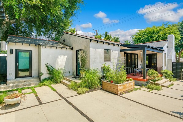 A modern house with a covered patio, a small garden, and a garage. - Oak Haven (Altadena)