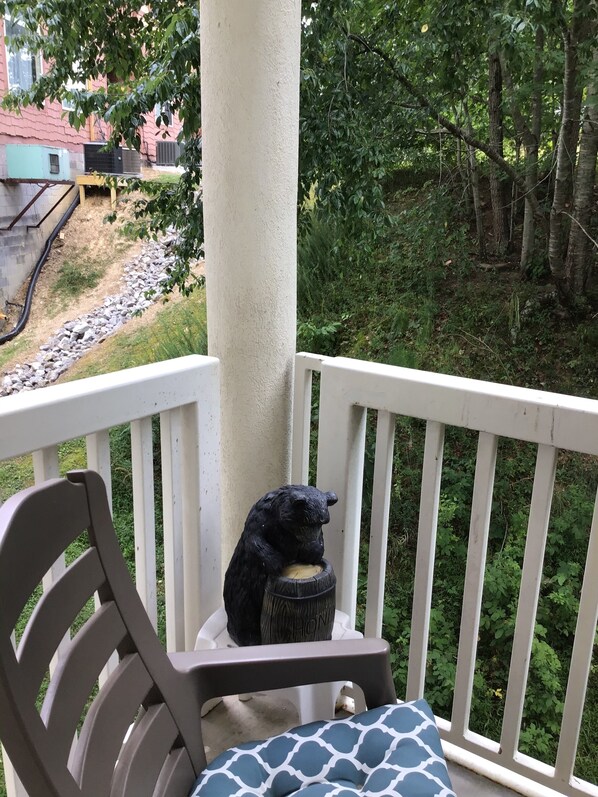 A porch with a chair and a bear statue. - Beautiful condo next to Golf course (Pigeon Forge)