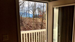Ein Zimmer mit einer Schiebetür und Zugang zu einer Terrasse mit weißer Geländer.