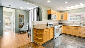 A modern kitchen with wooden cabinets, a microwave, and a stove.