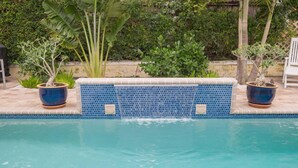 A swimming pool with a tiled edge and potted plants. - Palm Terrace (Delray Beach)