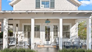 A white house with a covered porch, numbered 265, featuring a sign that reads "SHELL BEACH." - Luxury Watersound Getaway with Golf Cart (Watersound)