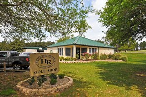 A golf shop with a green roof, surrounded by a well-maintained lawn and trees. - Enjoy Serenity by the Pool! VALUE! Family Memories Made! (Davenport)