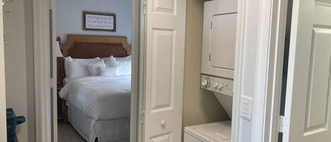 Een hotelkamer met een bed, een bord aan de muur en een wasmachine.