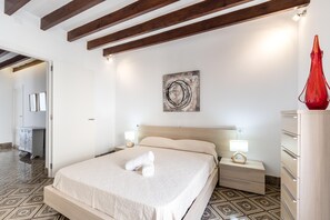 A hotel room with a bed, bedside tables, a dresser, and a red vase. - BUGERA. Beautiful restored house in Pollensa (Pollensa)