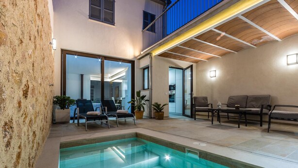 A modern indoor pool area with a glass enclosure, seating, and a balcony. - BUGERA. Beautiful restored house in Pollensa (Pollensa)