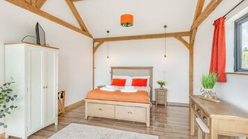 A bedroom with a bed, wardrobe, desk, and a window with curtains.