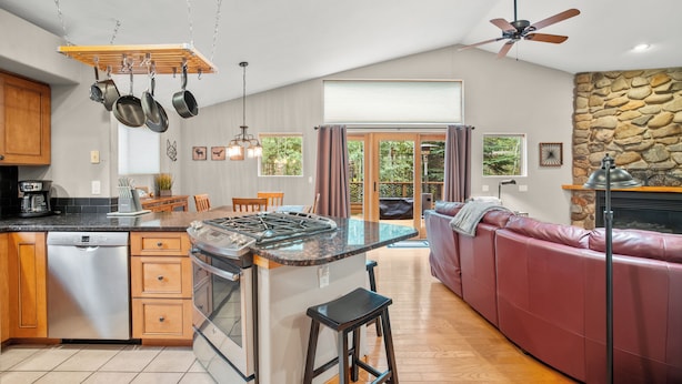 A modern kitchen with a central island, wooden cabinets, and a built-in dishwasher. - Quiet Townhouse Snuggled up to a Wooded Mountain View CS1 (Silverthorne)