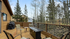 A deck with outdoor seating, a grill, and a view of the surrounding forest. - Quiet Townhouse Snuggled up to a Wooded Mountain View CS1 (Silverthorne)