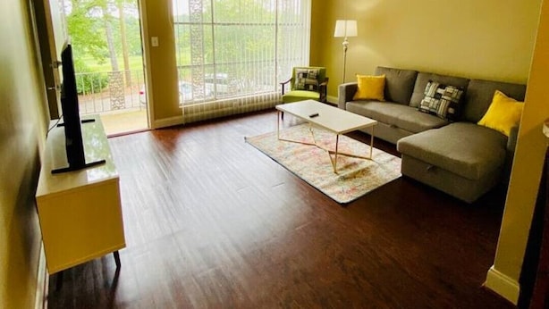 A spacious living room with a large window, a sofa, a coffee table, and a television on a stand. - 1st Floor Highlands Hideaway (Spectacular Views) (Birmingham)