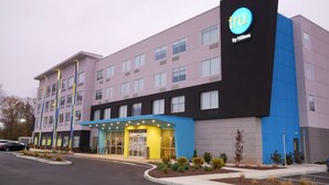 A modern hotel building with a prominent 'TRU by Hilton' sign, multiple floors, and a well-lit entrance area. - Tru By Hilton Chambersburg, PA (Chambersburg)