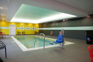 Una piscina techada, sillones reclinables de piscina