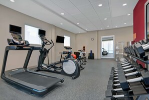 A gym with treadmills, an elliptical, and a rack of dumbbells. - Home2 Suites by Hilton Panama City Beach, FL (Panama City Beach)