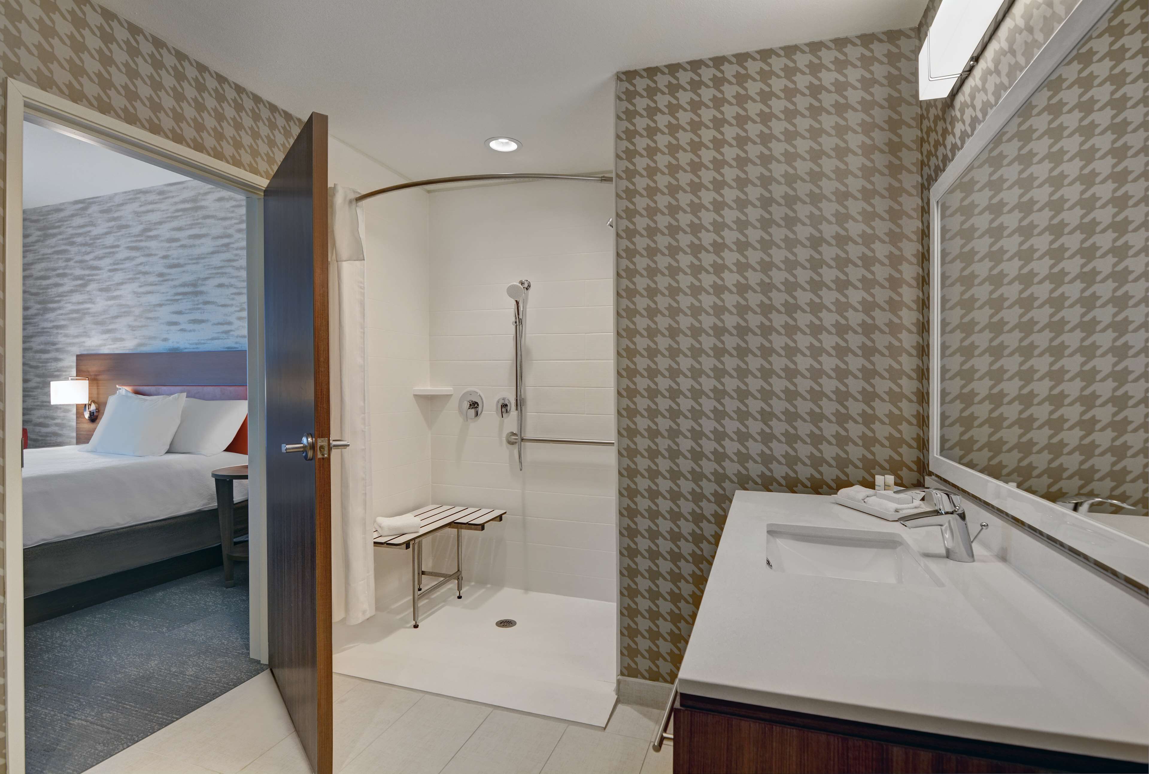 Un baño moderno con ducha, lavabo y espejo.