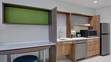 Una cocina moderna con microondas integrado, refrigerador y armarios de madera.