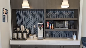 Eine moderne Küchenzeile mit Kaffeemaschine, Mikrowelle und Stauraumschränken.