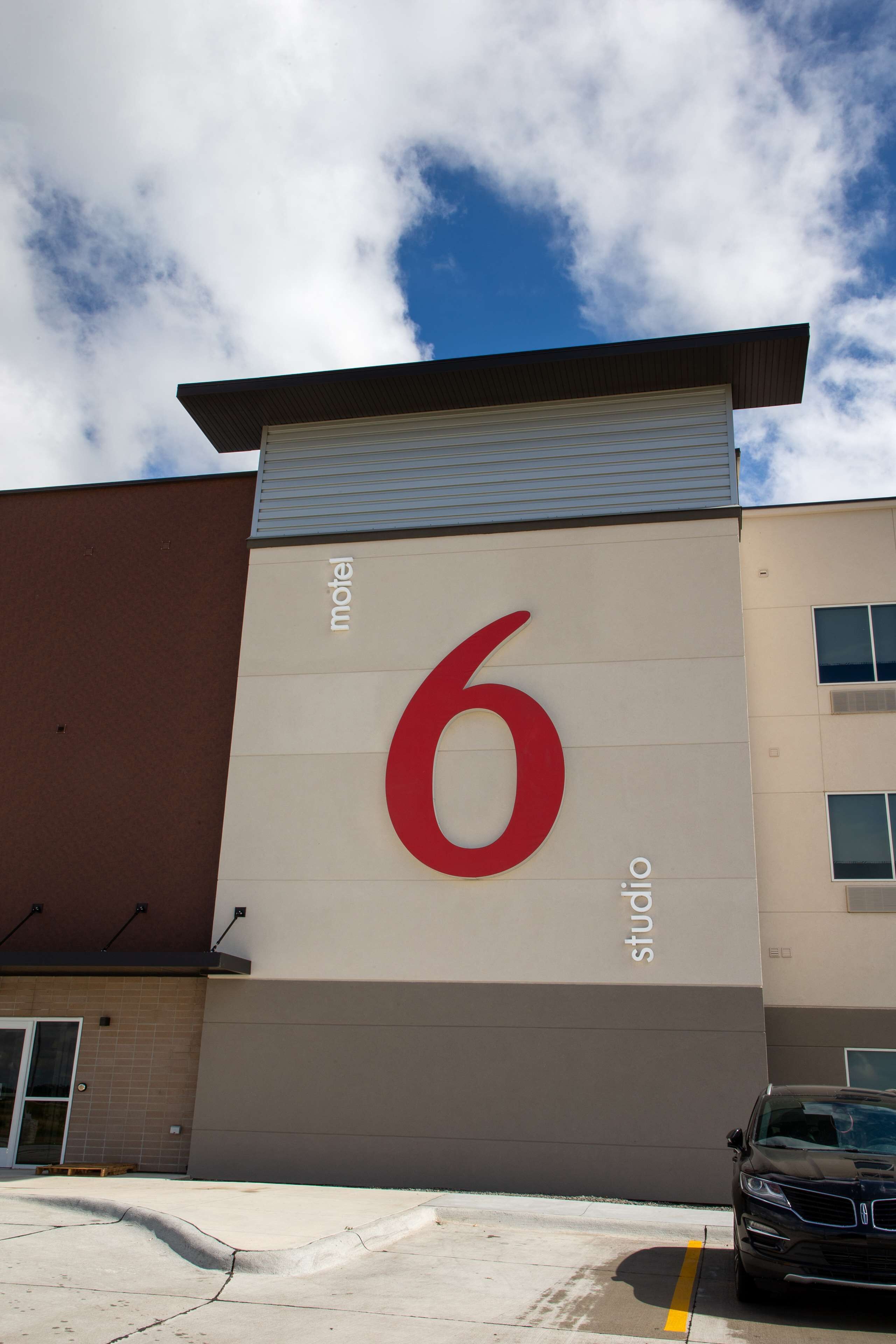 Un edificio con un cartel grande que muestra el número '6', indicando que es el sexto motel de una cadena.