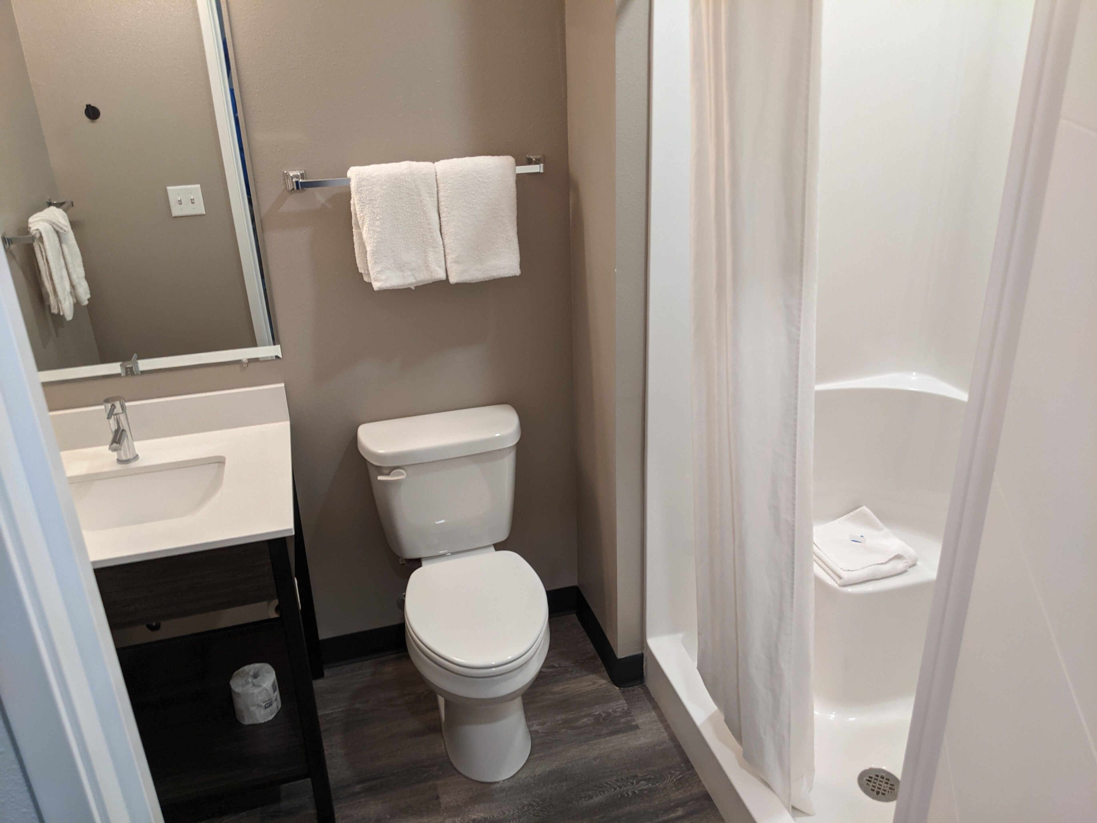 A bathroom with a toilet, sink, and shower.