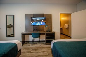A hotel room with a bed, a desk with a computer, a chair, and a television mounted on the wall. - Motel 6 North Platte, NE - East (North Platte)