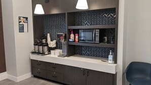 A modern kitchenette with a microwave, coffee maker, and storage cabinets. - Motel 6 North Platte, NE - East (North Platte)