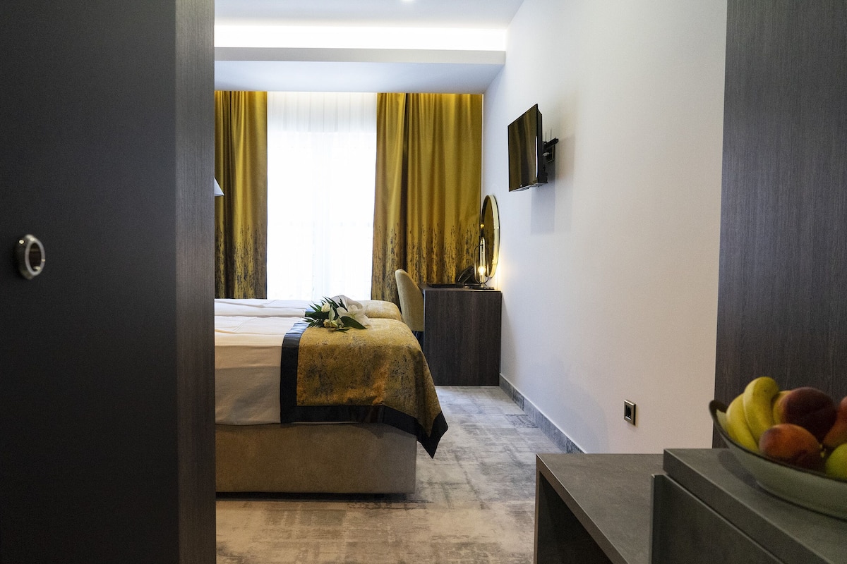 Ein modernes Hotelzimmer mit Bett, Schreibtisch und Obstschale.