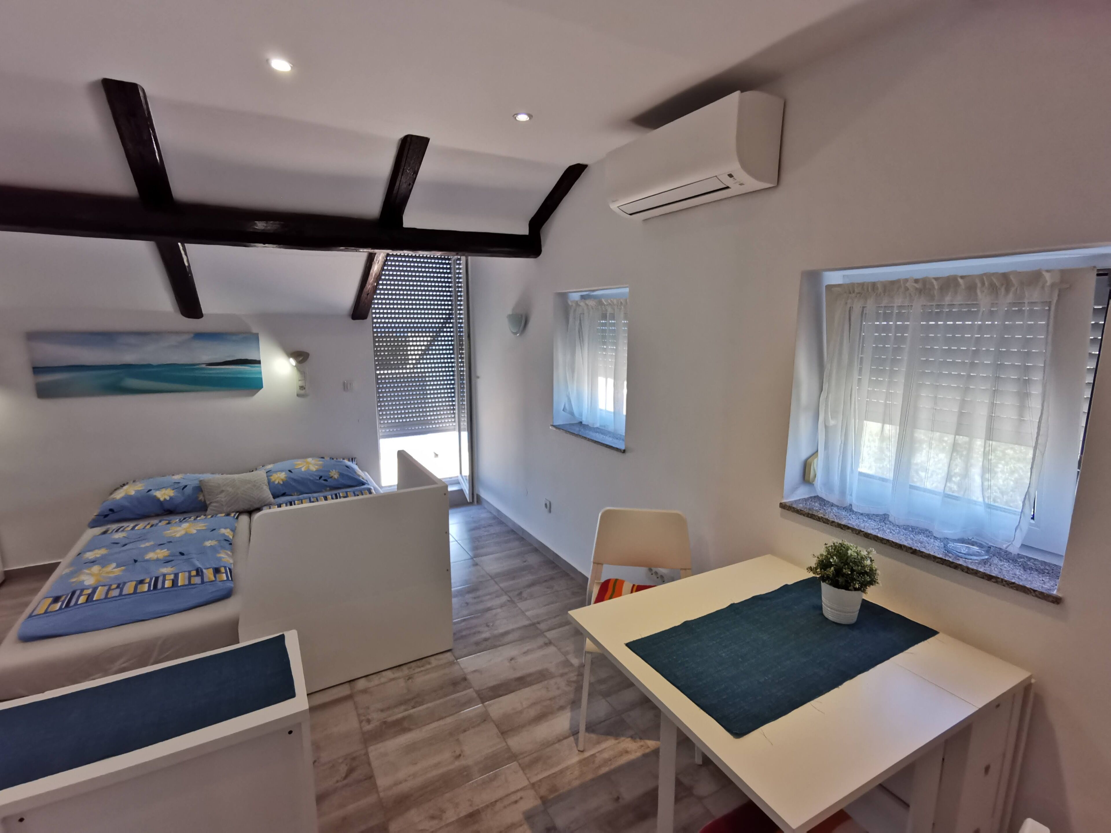 A modern room with a bed, a desk, and a window.