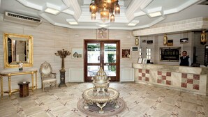 A lobby with a reception desk, a decorative fountain, and a large mirror. - Hotel Residence Mahmoud (Hammamet)