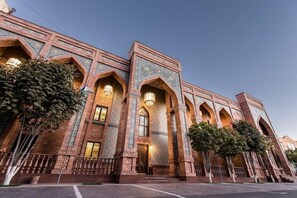 A hotel with a traditional architectural style, featuring arched windows and detailed brickwork.