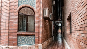 A narrow alleyway with brick walls and patterned tiles.