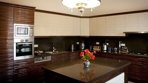 A modern kitchen with built-in appliances, a central island, and a decorative chandelier.