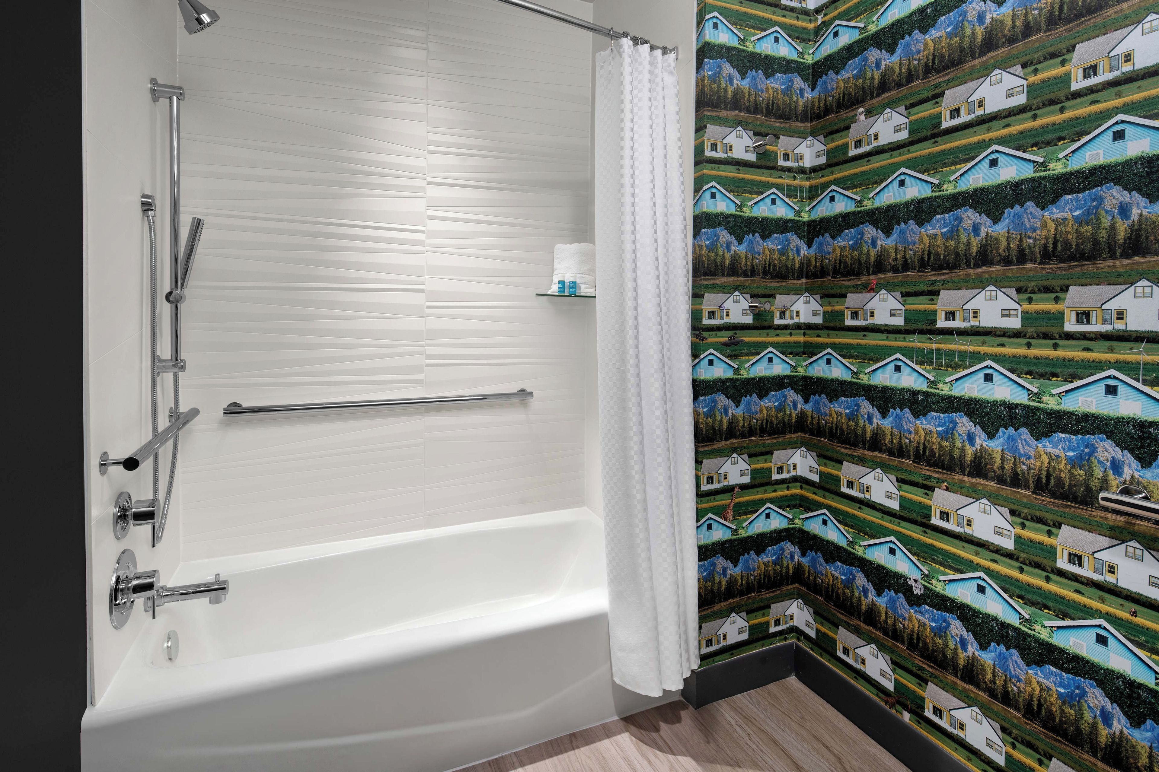 Une salle de bain avec une baignoire, une douche et un porte-serviettes.