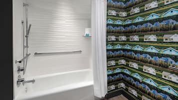Een badkamer met een bad, een douche en een handdoekrek.