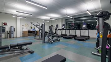 Una palestra con tapis roulant, macchinari ellittici e attrezzature per l'allenamento con i pesi.
