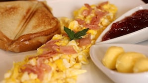 Scrambled eggs with ham, toast, and a side of jam and boiled eggs. - Hotel Rincon de la Alameda (Quito)