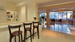 A hotel lobby with a reception desk, bar area, and seating arrangement. - Golden Line (Varna)
